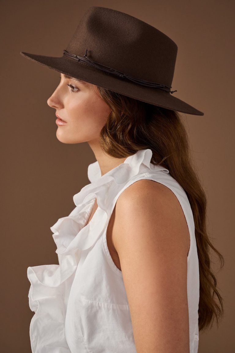 Fashion model in fotostudio die een hoed draagt van het merk Bronté Amsterdam.