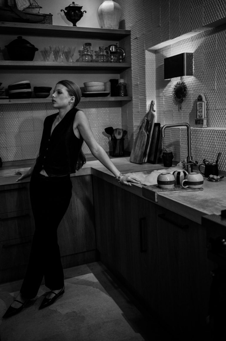 Model leunt op aanrecht van keuken in locatiehuis te Amsterdam voor mode serie met stylist Phoebe Vos